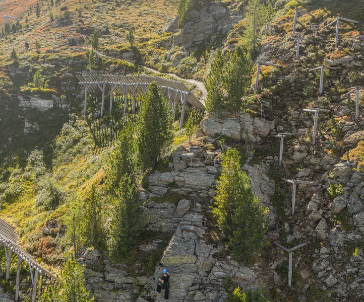 Panorama Klettersteig Ahrntal mit Kletterer, Seilbahn-Bergstation und herbstlicher Almlandschaft