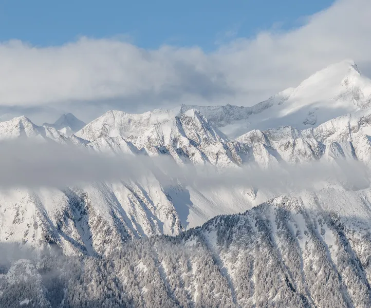 Winterliches Bergpanorama im Ahrntal mit schneebedeckten Gipfeln und Nadelwäldern