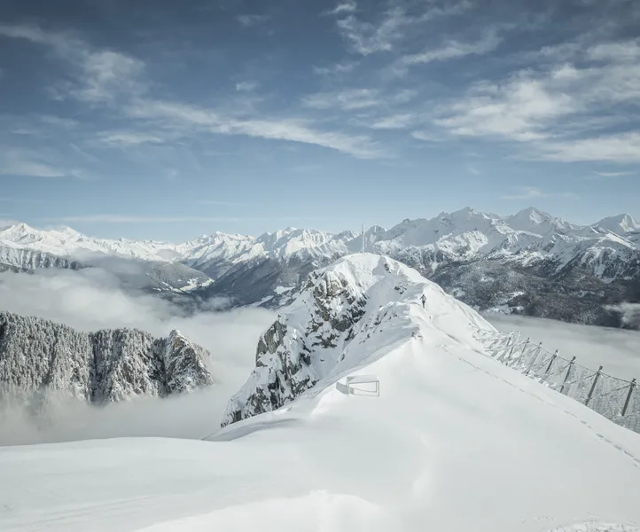 Verschneiter Gipfelgrat mit Lawinenzäunen über dem Nebelmeer im Ahrntal, Zillertaler Alpen