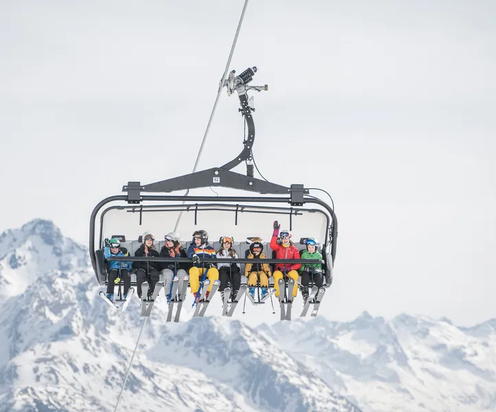 Besetzter Sessellift mit Kindern und Jugendlichen vor Bergpanorama – Liftfahrt im Skigebiet Ahrntal