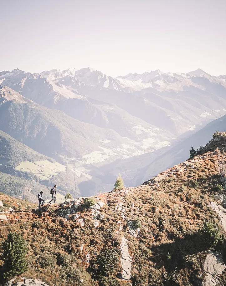 Zwei Wanderer auf herbstlichem Bergrücken am Speikboden mit Blick ins grüne Ahrntal