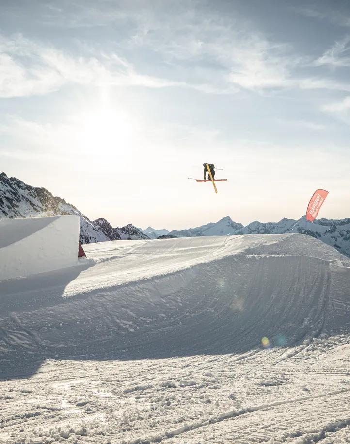 Freestyle-Skifahrer beim Rotation-Trick im Snowpark Klausberg mit Bergpanorama und Gondel