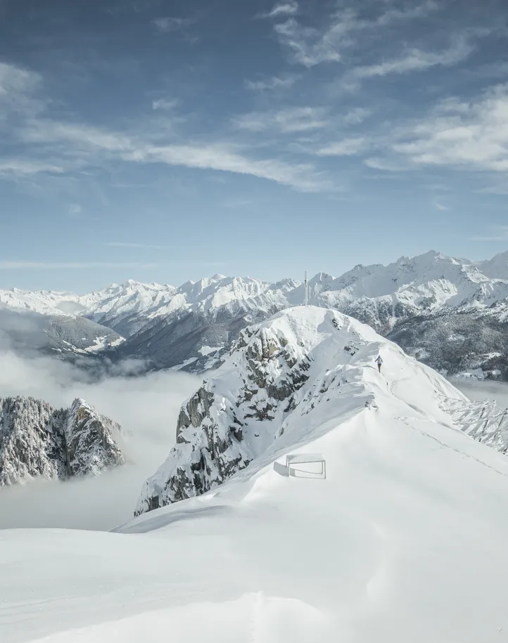 Verschneiter Gipfelgrat mit Lawinenzäunen über dem Nebelmeer im Ahrntal, Zillertaler Alpen