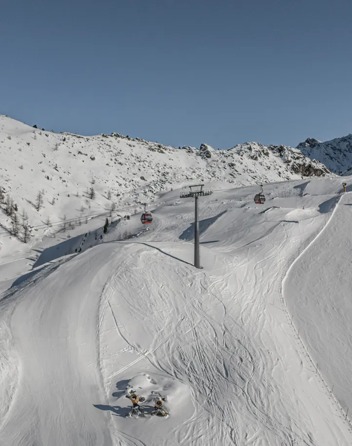 Blick auf die präparierten Pisten am Klausberg mit roten Gondeln und Schneekanonen im Ahrntal