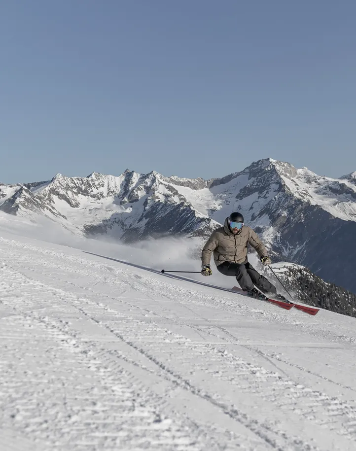 Young couple on Speikboden chairlift smiling towards the horizon, Skiworld Ahrntal winter scenery
