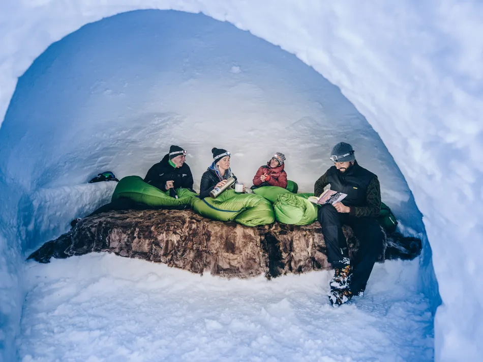Cosy igloo overnight stay in Ahrntal Valley – guests with headlamps inside a snow igloo