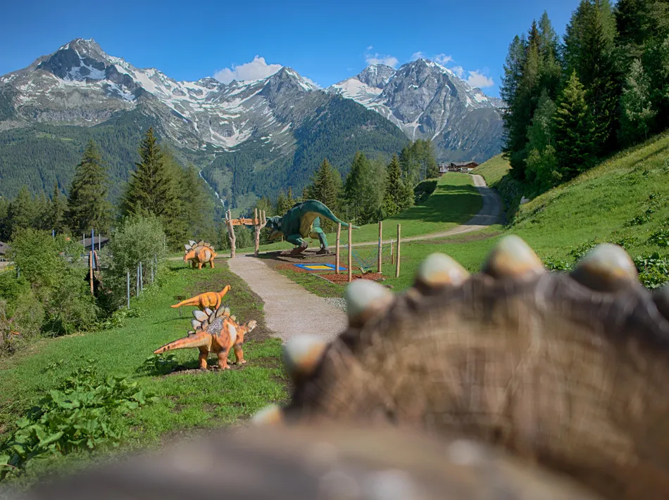 Klausberg Dinopark with dinosaur figures on an alpine meadow and stunning mountain panorama
