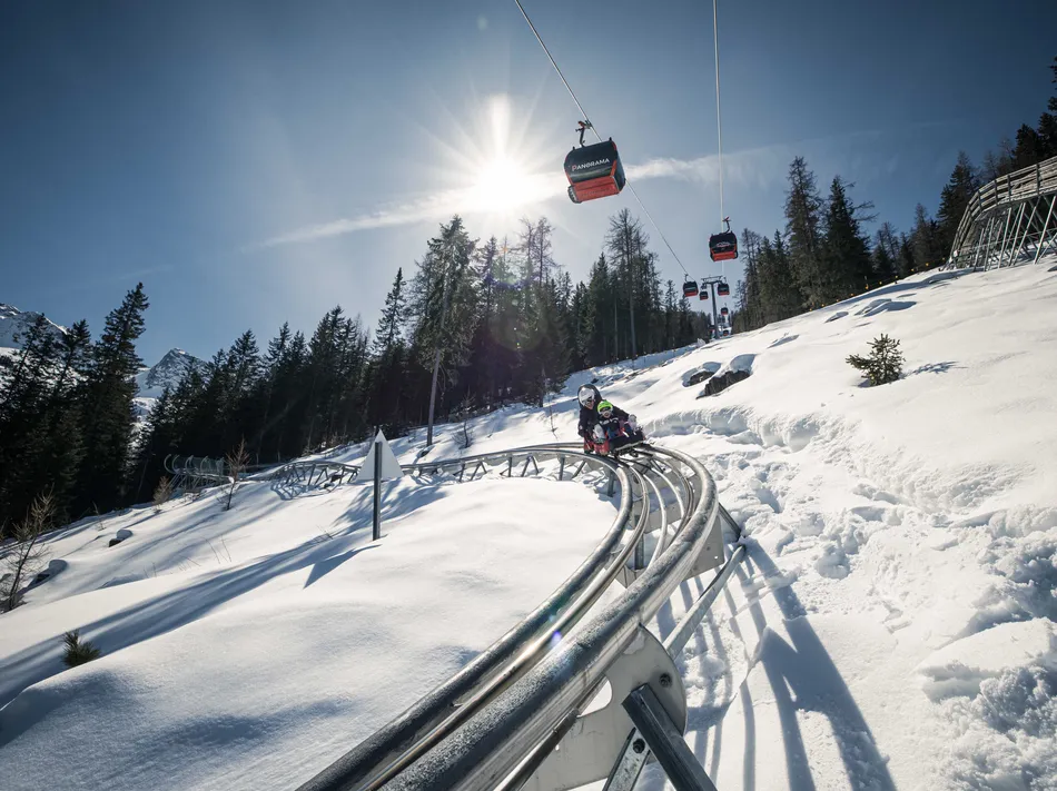 Alpine Coaster Klausberg – view of rail sled with panorama gondolas in backlight