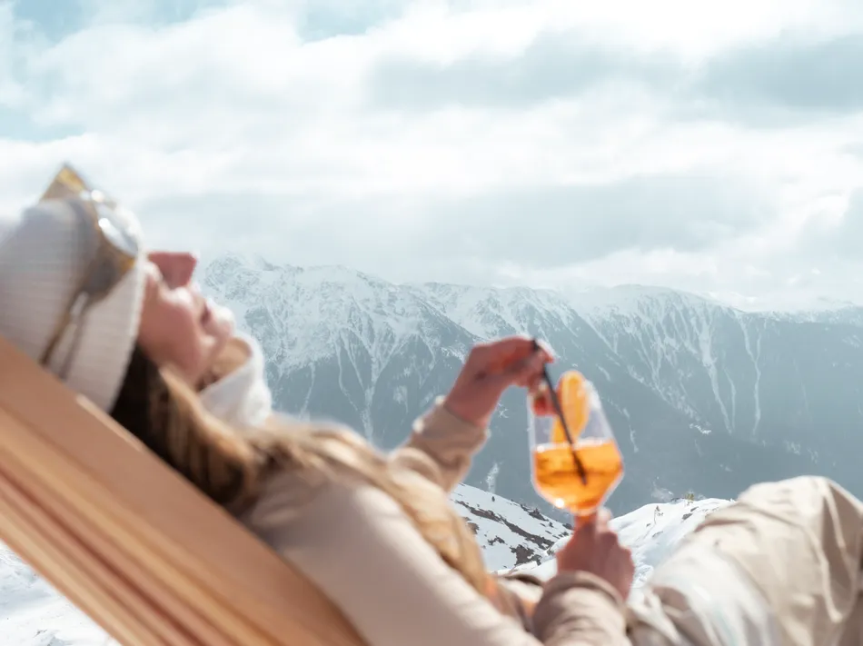 Après-Ski-Stimmung am Klausberg: Frau mit Aperol Spritz im Liegestuhl vor Bergpanorama