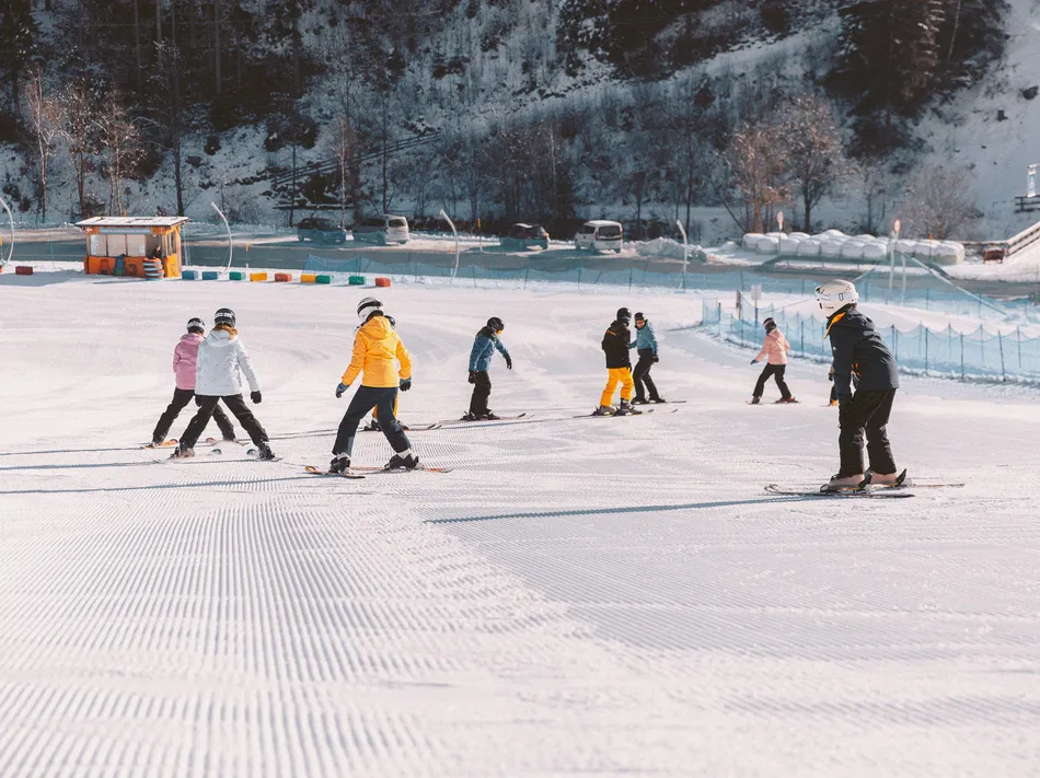 Ski students practicing on groomed beginner slope at Klausberg Speikboden ski resort Ahrntal